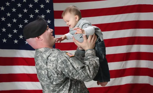 soldier Soldier holding baby in front of American Flag